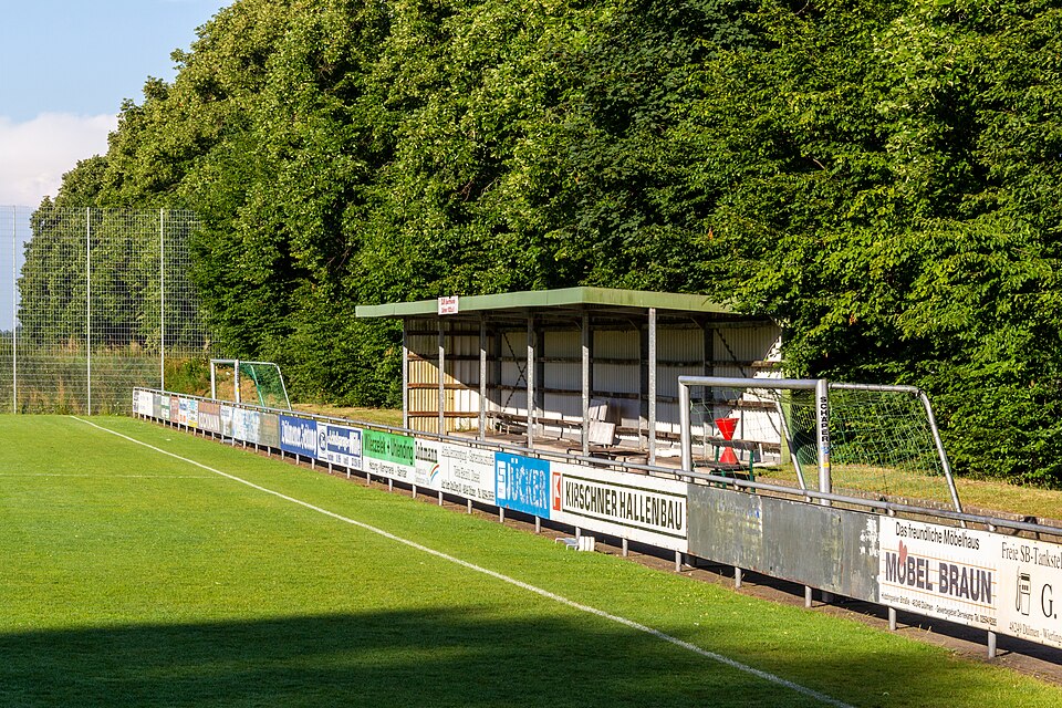 Aficionados siguiendo un partido de fútbol en un bar deportivo