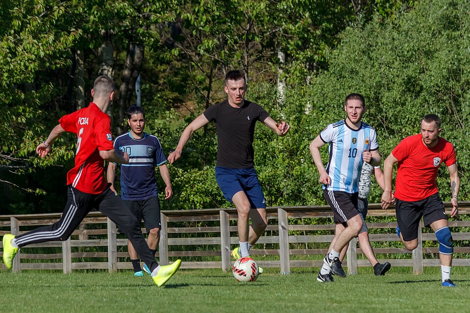 Vista aérea de un partido nocturno con estadio lleno